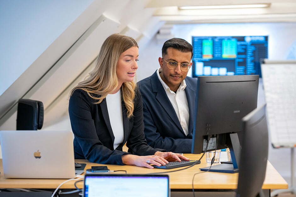 To sælgere fra Nordic Sales Force arbejder sammen ved skærmen